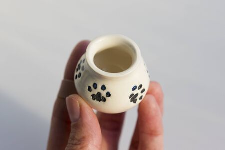small white potty with cat's legs. prints of cat's paws. ceramic product. author's work.の写真素材