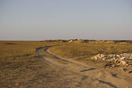 limestone and gravel mining for the construction of a road in the steppe. Pit dug by the excavator near to the old road and future road.の写真素材