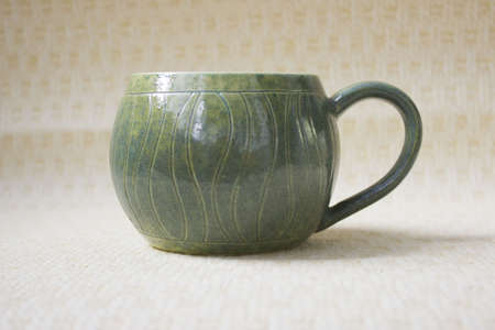 pot-bellied mug made of clay with a spectacular aqua glaze in the estuary. ceramics, handmade. reminder of the sea and travel. changes color depending on lightingの写真素材