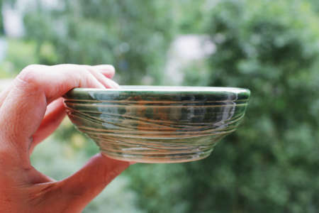 handmade green ceramic plate. made on a potter's wheel, covered with spectacular glaze, passed two firing.の写真素材