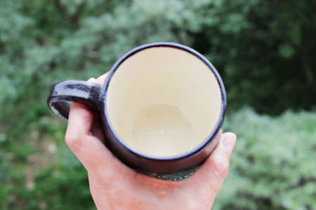 black mug made of clay. decor - covering with black engobe and transparent glaze. two firing. made on a potter's wheel. handmade.の写真素材