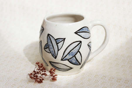 handmade ceramic cup with leaves. clay covered with engob, glaze and passed two firingの写真素材