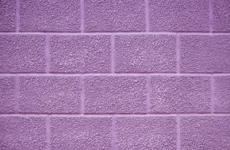 purple wall of the house on the street. the plaster has a texture and is covered with paint....