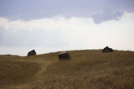 landscape with hills, three big stones and blue sky. south of russia, summer. yellow grass in late Augustの写真素材