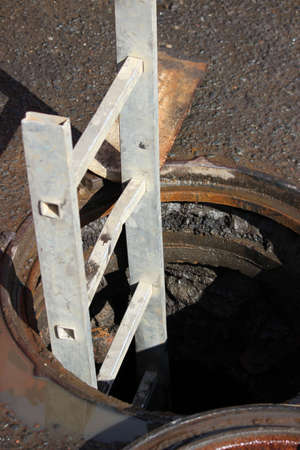 staircase and open hatch. Repair work on sewage pipesの写真素材