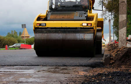 road roller compactor at work. asphalt pavement works for road repairing. expansion and repair of the roadway at the exit from the city of Gatchina, Russiaの写真素材