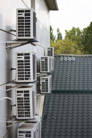 group of old outdoor air conditioner units on the facade of the houseの写真素材
