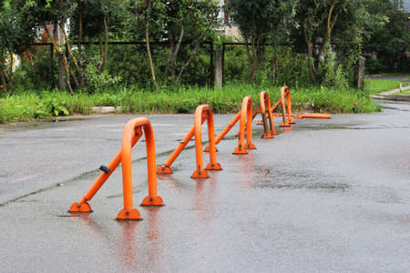 orange parking barriers, parking space limiters and blockers. Parking and road equipmentの写真素材