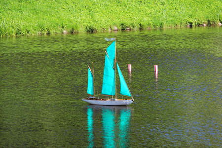 small turquoise sailboat on the lake, controlled remotelyの写真素材