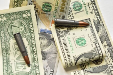 cartridges for machine guns on dollar bills. military business concept. close up top view shotの写真素材