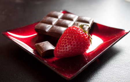 red fresh delicious strawberry on black with back light