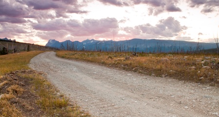 old country road in eastern montana with large mountain range in the backgroundの写真素材