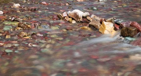 color filled rocks with clean clear water flowing over them using s alow shutter speed