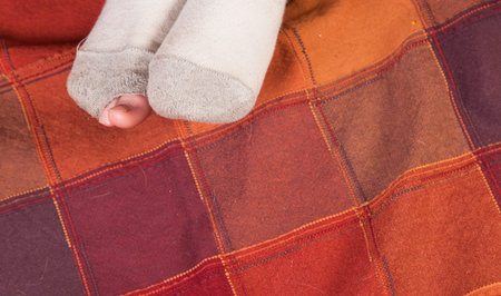 worn out socks dirty with a hole and toes sticking out of one of them over a colorful background