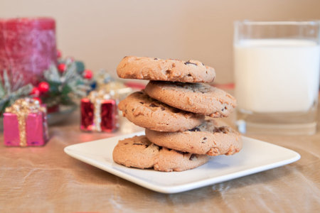Chocolate chip cookies and milk as a center piece for a chritmas scene on a golden place mat