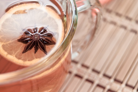 close up of an Anise star floating with an orange star in a hot cup of teaの写真素材