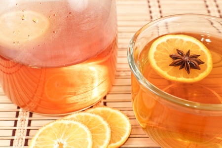 close up of an Anise star floating with an orange star in a hot cup of teaの写真素材