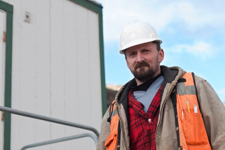 portrait of a construction worker walking wearing a hard hat and an orange vest