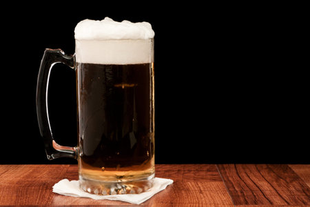 light pilsner served in a frosted mug isolated on a black backgound