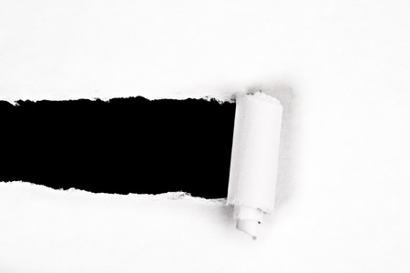 ripped white piece of paper on a black background with rough edgesの写真素材