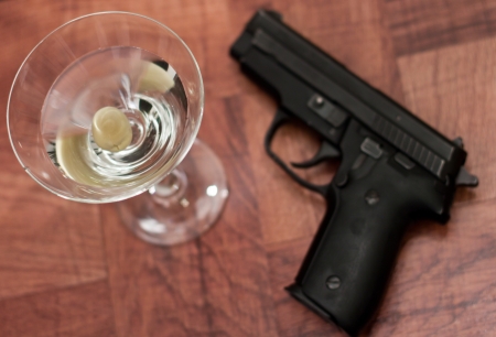 closeup of a martini on a bar top with an out of focus gunの写真素材
