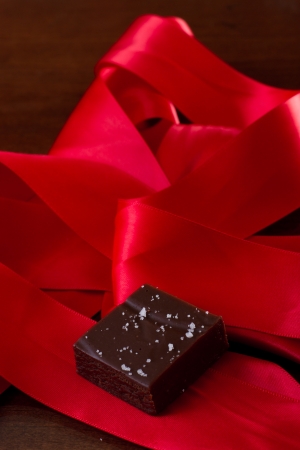 home made caramel with sea salt with a red silk bowの写真素材