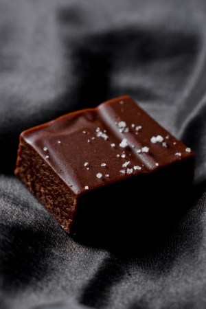 salted caramel square served on a black silk backgroundの写真素材