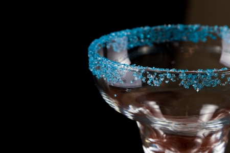margarita glass decorated with blue salt rim, served on a dark bar fading into blackの写真素材