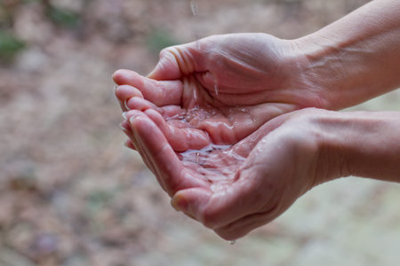 closeup of a female hand holding a small amount of water on her hand
