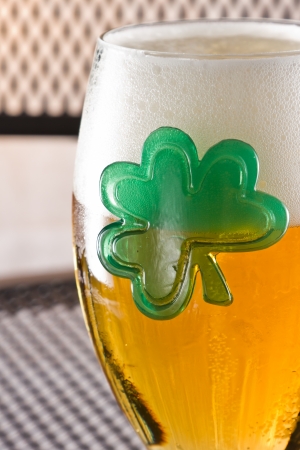 closeup of a beer with a green shamrock clinging to the side of the chaliceの写真素材