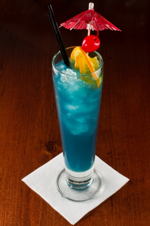 tropical blue cocktail served on a out of focus barの写真素材
