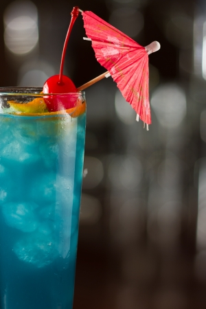 tropical blue cocktail served on a out of focus barの写真素材