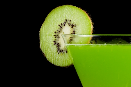 stemless martini with a green vibrant drink garnished with a kiwi sliceの写真素材