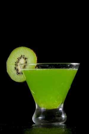 stemless martini with a green vibrant drink garnished with a kiwi sliceの写真素材