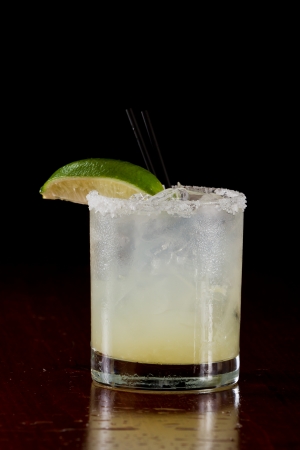fresh lime juice margarita served on the rocks in a dark restaurantの写真素材
