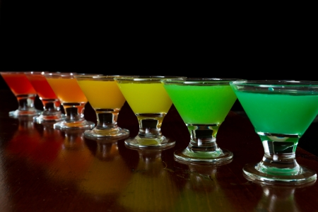 classic bar flair trick, rainbow colored juice served in multiple shot glasses in a rowの写真素材