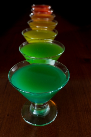 classic bar flair trick, rainbow colored juice served in multiple shot glasses in a rowの写真素材