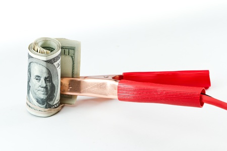 booster cables attached to a roll of one hundred dollar bills on a white backgroundの写真素材
