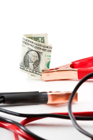 booster cables attached to a american dollar bill on a white backgroundの写真素材