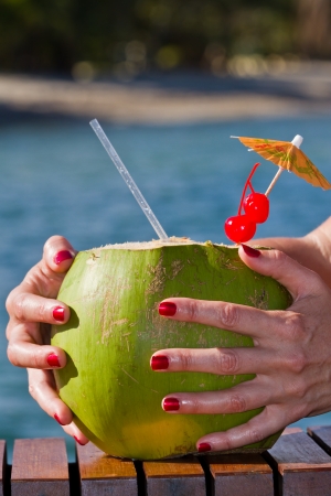 coconut drink served in a green coconut with rum and juices served on the beach of Belizeの写真素材