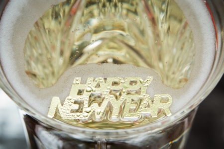 happy new year in golden letters floating in champagneの写真素材