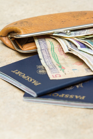 travel documents and different international currencies on a counter topの写真素材