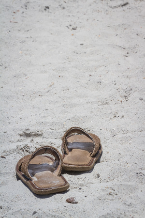 empty sandals on a florida beach with white sand under bright sunの写真素材