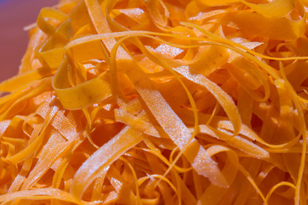 close up of a pile of shredded carrots with vivid orange color