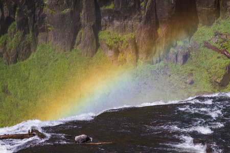 upper mesa falls in western Idaho with a faint rainbow formed by the mist produced by the fallsの写真素材