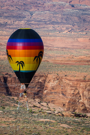 hot air balloon floating over the red navajo sandstone in Arizona with a beautiful landscapeの写真素材