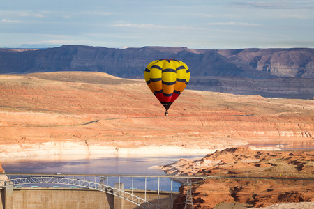 hot air balloon floating over the Glen Canyon Dam in Arizona with a beautiful landscapeの写真素材