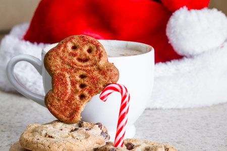 hot chocolate with a gingerbread man with a missing foot using a candy cane