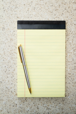 close up of a blank note pad and a pen for a home office conceptの写真素材