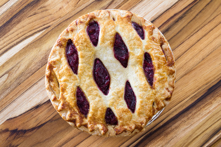 view form above of a fresh baked cherry pie on a wooden tableの写真素材